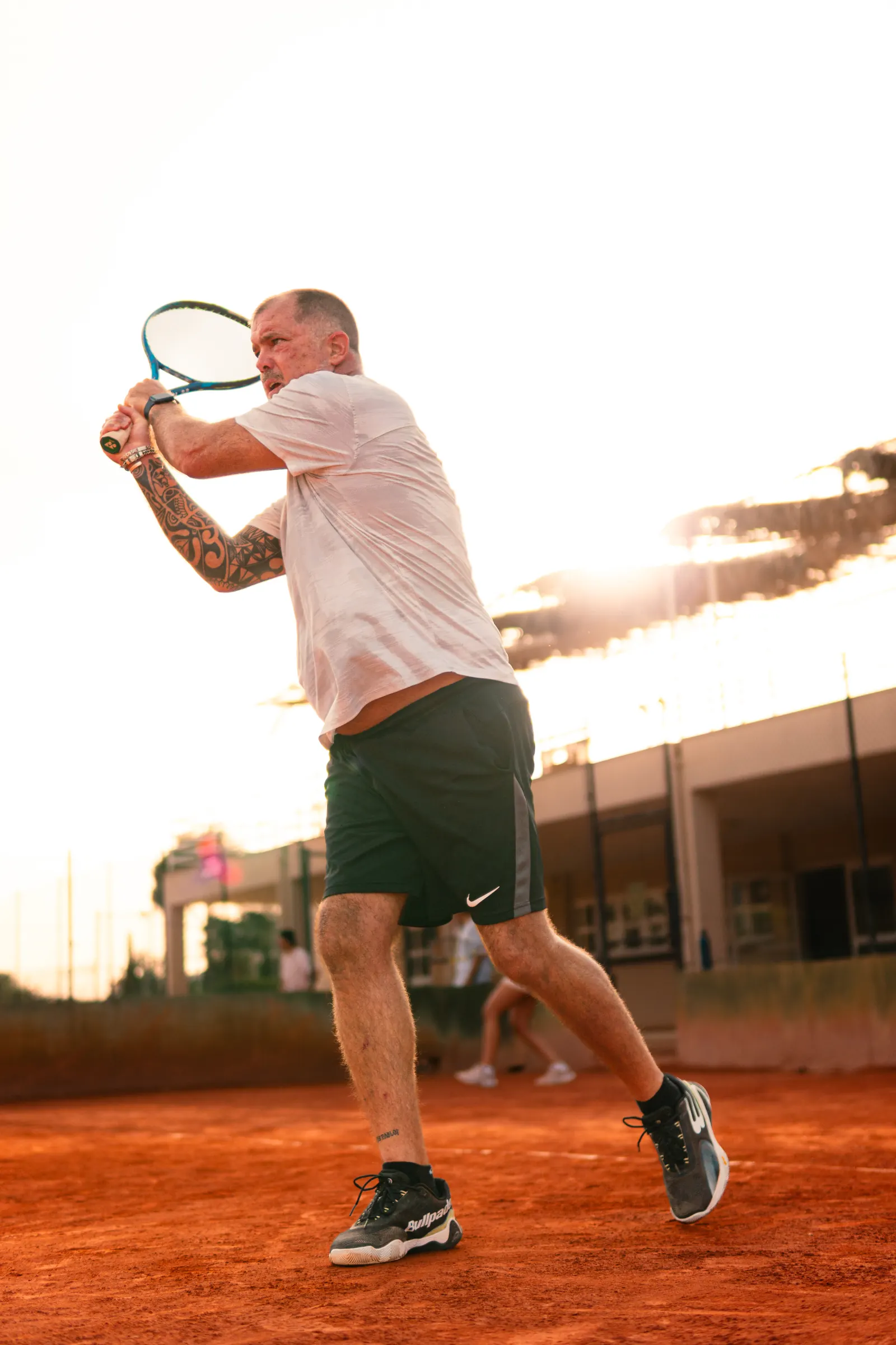 Jugador de Club Momentum en la pista de tierra batida al atardecer
